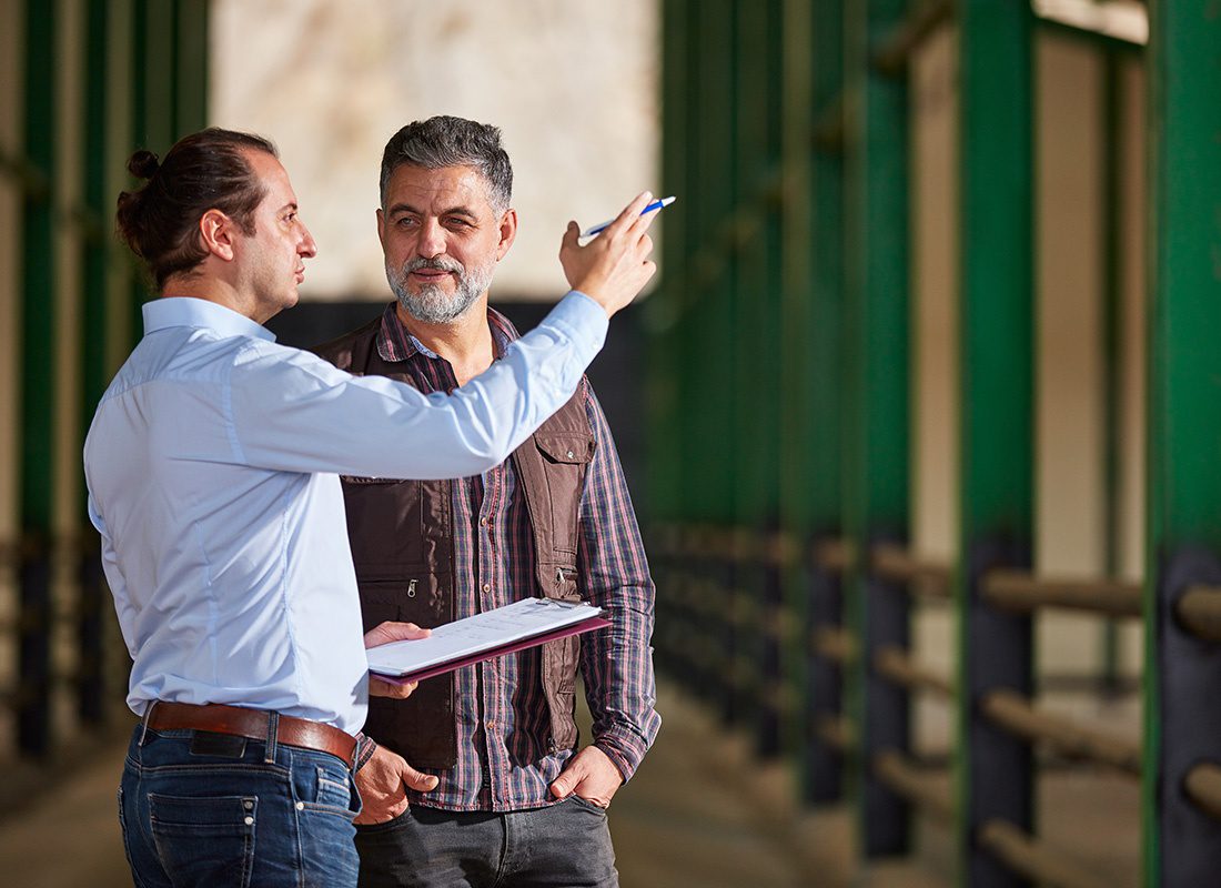 Contact - Agent With Clipboard Speaks With a Farmer at His Farm